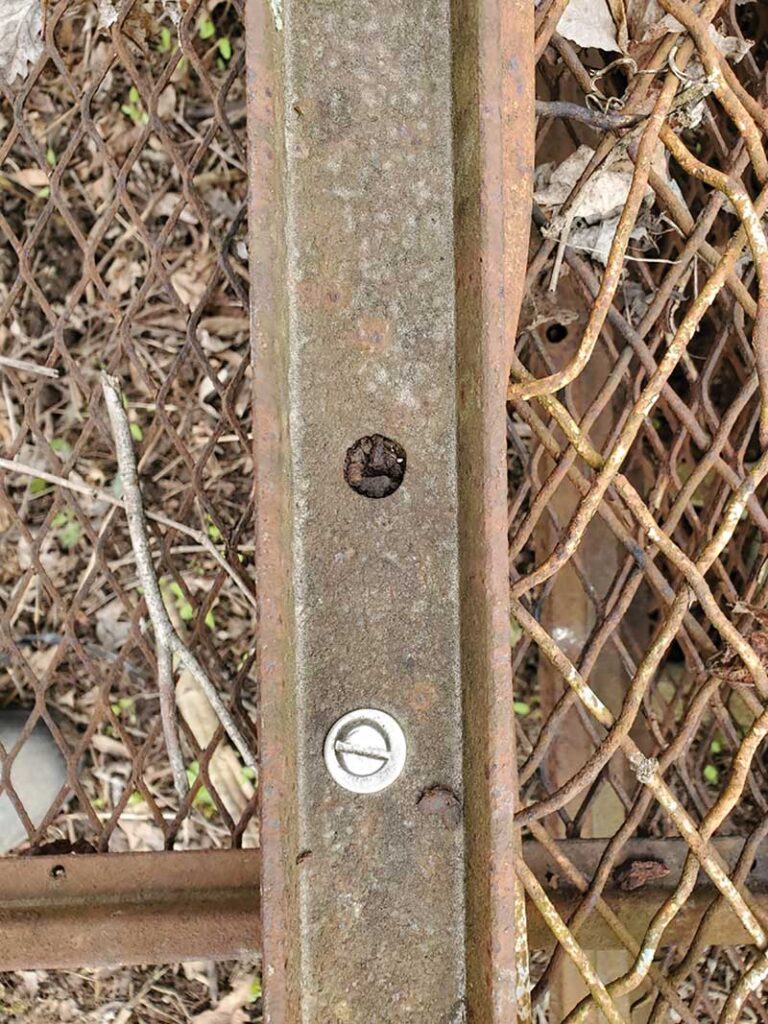 Photo 1. Corroded steel frame with intact stainless-steel screw