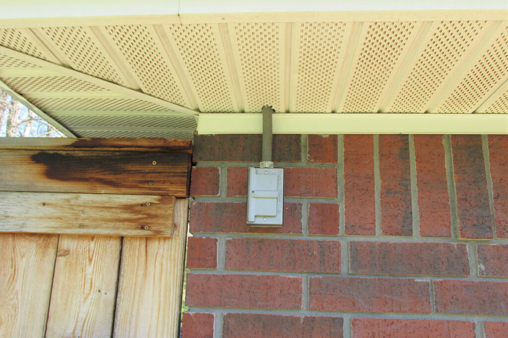 Photo 1a. A determination by the AHJ has determined this receptacle outlet located beneath the soffit as a damp location, thus allowing a flip type cover.
