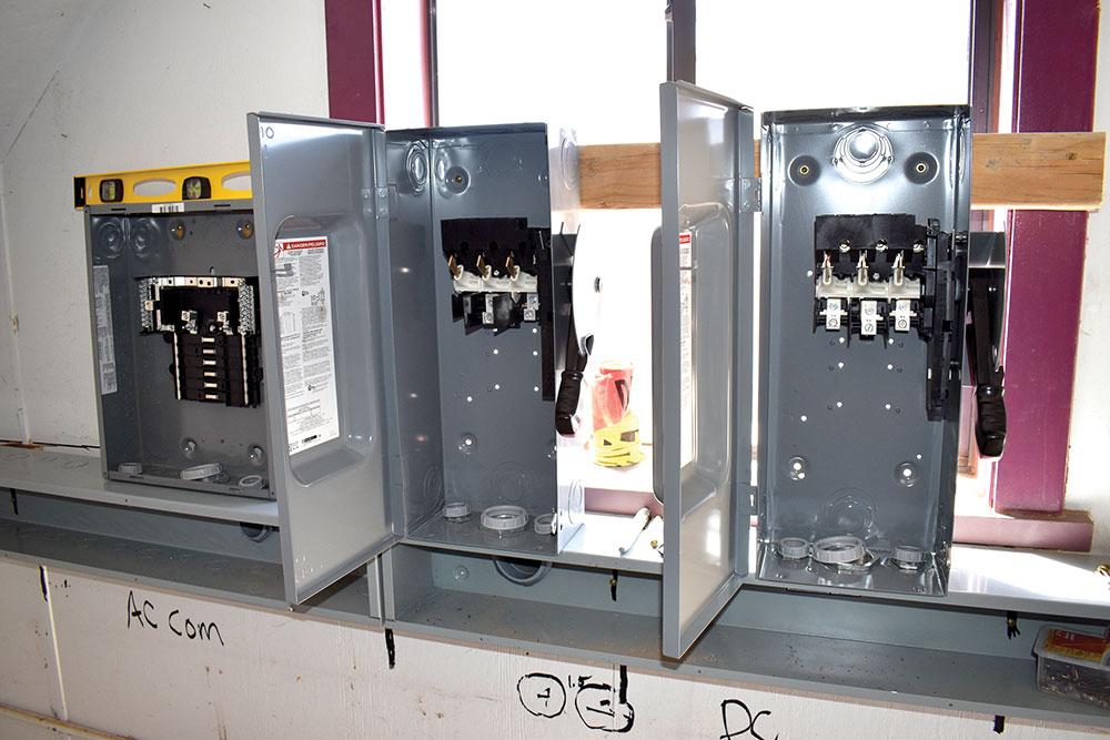 Photo 5. 240V, 100A AC load center on the left. 600V, 100A DC disconnects on the right. Courtesy of John Wiles