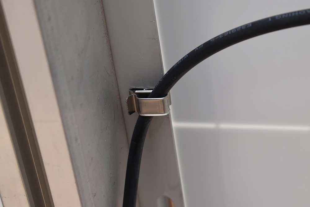 Photo 6. Cable properly secured to module frame with a metal cable clip. Courtesy of John Wiles